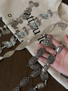 Detail of bohemian silver metal waist chains with turquoise butterflies and coins