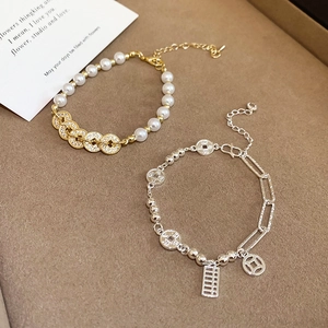 Detailed view of elegant pearl bracelets with retro coin pendants and zircon accents