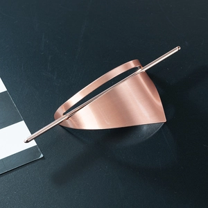 Macro detail of rose gold geometric hair pin showing brushed metal texture and modern finish