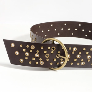 Macro detail of dark brown leather belt with gold metal rivets and round buckle
