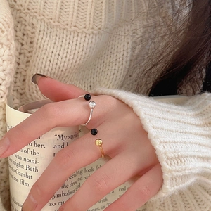 Close-up of S925 silver and gold-plated open rings featuring black agate bead accents