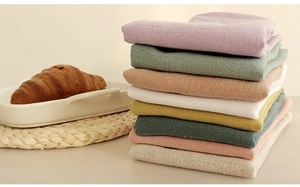 Stacked colorful waffle weave linen napkins in various shades for Nordic kitchen decor