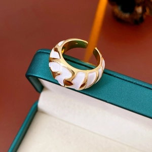 Detailed view of adjustable golden ring with white enamel shell texture in a jewelry box