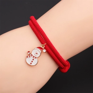 Close-up of a red woven rope bracelet with a snowman enamel pendant on a model's wrist