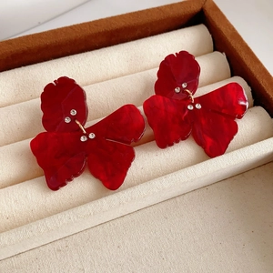 Close-up of red resin butterfly earrings with sparkling rhinestones in a jewelry box
