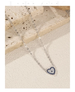 Macro shot of S925 sterling silver heart evil eye pendant necklace with blue stones