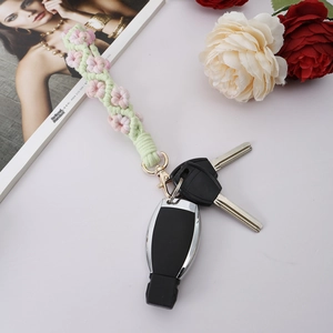 Detail of handmade crochet pink flower keychain with gold clasp on car keys