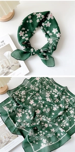 Detail of dark green cotton linen scarf with cherry blossom pattern and fine hemmed edges