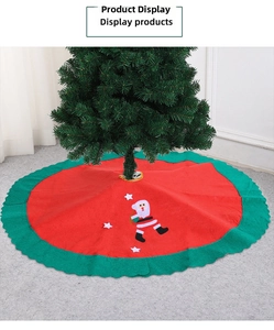Detail of red Christmas tree skirt with Santa Claus applique and green wavy edges