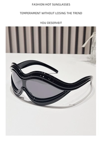 Detail of trendy Y2K black oversized sunglasses with unique wavy layered frame design