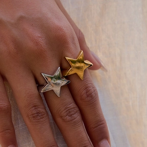 Detail of gold and silver star rings with Blessing engraving on striped fabric