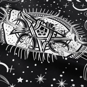 Detail of fabric texture showing black and white occult sun, moon, and skull pattern