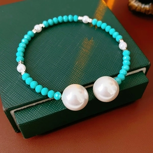 Détail d'un bracelet vintage français avec cristaux bleus et grandes perles blanches