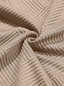 Macro texture of khaki jacquard knit fabric showing geometric 3D pattern and softness