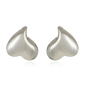 Macro shot of silver irregular heart earrings with mirror polished metallic finish