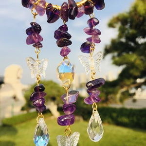 Close-up of purple crystal suncatcher with butterfly pendant and faceted drop bead