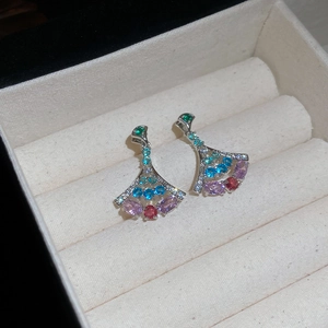 Detail of fan-shaped silver needle earrings with multicolor zircon stones in jewelry box