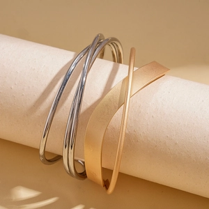 Minimalist geometric stacked silver and gold metal cuff bracelets with polished finish