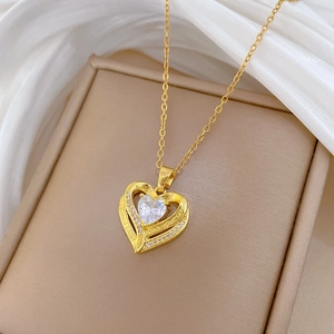 Detail of gold heart pendant with engraved I love you message and cubic zirconia
