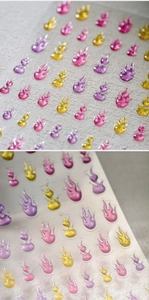 Detailed 3D flame nail stickers with glitter finish in purple, pink and yellow tones