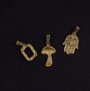 Detailed shot of 24K gold-plated mushroom, Hamsa hand, and rectangle metal pendants