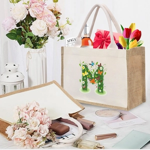 Detail view of cotton linen tote bag with floral letter M print and natural jute texture