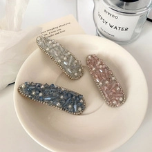 Detailaufnahme von Haarspangen mit Strass und Perlen auf einem weißen Keramikteller