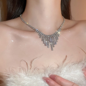Close-up of a silver necklace with sparkling zircon fringe tassel on a fashion model