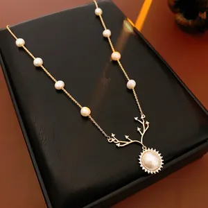 Vintage gold necklace with pearl deer antlers and sunburst pendant on black box