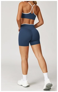 Rückansicht von blauem Yoga-Set mit weißen überkreuzten Trägern und hoher Taille Shorts