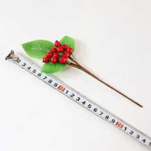 Close-up of artificial red berries with measuring tape showing 24.5cm length