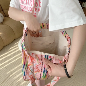 Détail de l'intérieur du cabas en toile rose montrant la doublure, la poche zippée et le fermoir