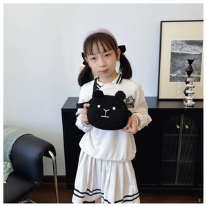 Close-up of black plush teddy bear crossbody bag with soft fleece fabric and embroidery