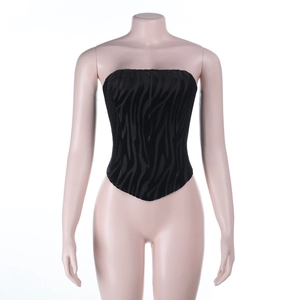 Detail of black corset top with textured tiger stripe flocking and pointed hemline
