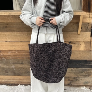 Detail of large leopard print canvas tote bag with shoulder straps and front pocket