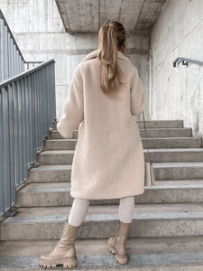 Rear view of a mid-length beige plush teddy coat with wide collar on a model
