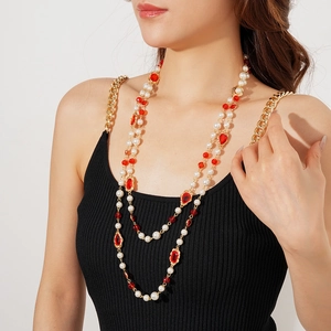 Detail of vintage multi-layer pearl necklace with red oval gemstone in gold setting