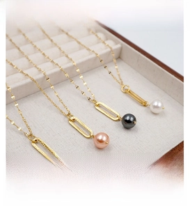 Detail of four colorful pearl necklaces with golden oval frames in a wooden jewelry box