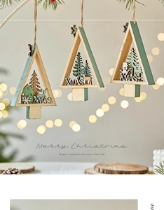 Close-up of wooden XMAS pendants with laser-cut reindeer and tree hanging on pine branch