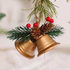 Close-up of golden Christmas bells with pine cones, red berries and green pine needles