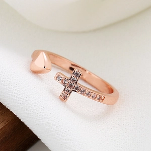 Rose gold adjustable ring featuring a polished heart and a sparkling cross with tiny diamonds
