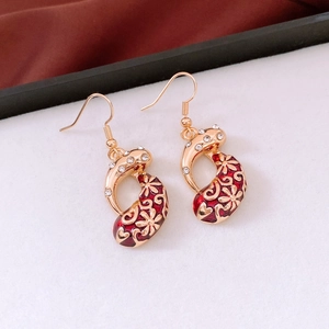 Close-up of vintage gold earrings with red enamel and sparkling zircon waterdrop accents