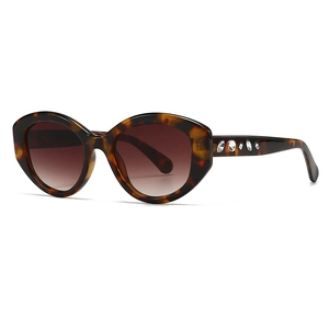 Oval tortoiseshell sunglasses with crystal embellishments and brown gradient lenses