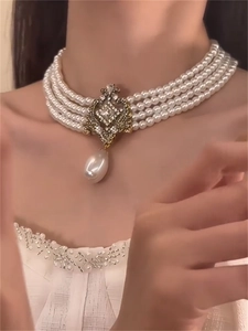 Detail of a vintage multi-layer pearl necklace with rhinestone flower and drop pearl pendant