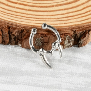 Silver stainless steel U-shaped fake septum nose ring with spiked ends on rustic wood background