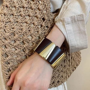Close-up of wide acrylic bracelet with vintage brown and gold panel design for women