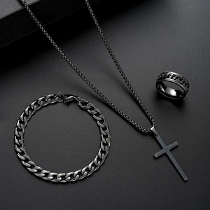 Macro shot of black stainless steel jewelry set featuring cross pendant and cuban link chain