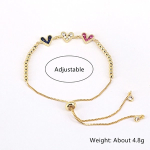 Detail of adjustable gold bracelet featuring heart charms with colorful zircon stones