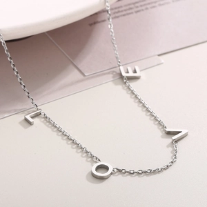 Collier élégant en acier inoxydable argenté avec design de lettres LOVE sur fond texturé