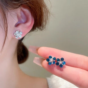 Detailed view of sweet five-petal flower stud earrings with faux pearls and rhinestones